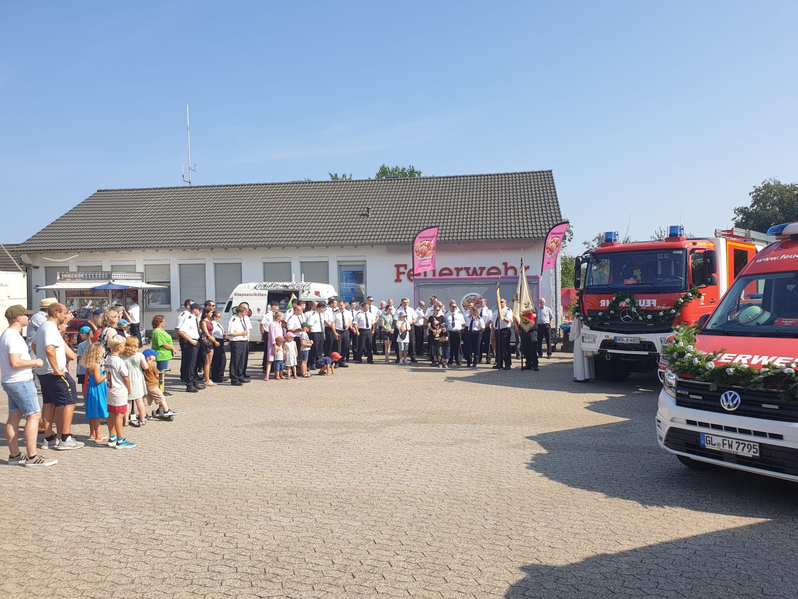 Fahrzeugsegnung und Festgesellschaft vor dem Feuerwehrgerätehaus der Einheit Scheuren